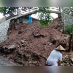 Kondisi jalan dan talud di Pacitan yang ambrol diterjang longsor.