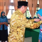 Wabup Pungkasiadi mengalungkan ID card kepada peserta jambore kader PKK. 