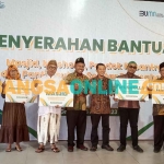 SVP PT Petrokimia Gresik, Yusuf Wibisono, dan Ketua DMI Gresik, Zainal Abidin, bersama para pengurus masjid, musalah, pondok pesantren, dan panti asuhan penetima bantuan. Foto: SYUHUD/BANGSAONLINE