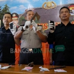 Petugas menunjukkan kapak dan pisau tajam yang digunakan pelaku begal. foto : RONY S/ BANGSAONLINE