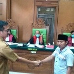 dr. Farhat Suryaningrat berjabat tangan dengan Moh. Hosen (terdakwa) usai sidang kedua di PN Negeri Bangkalan.