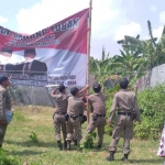 Petugas Satpol PP saat menurunkan banner yang diduga dipasang relawan Prabowo-Sandi.