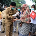 Plt. Wali Kota Pasuruan saat membagikan hand sanitizer ke salah satu warga.