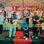 Kepala Desa Oro-Oro Ombo Kulon saat menyerahkan Piagam Penghargaan kepada Peserta Carnival dari Dusun Nganglang RT 02/ RW 01. Foto: M Andy Fachrudin/BANGSAONLINE