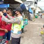 Anggota Polres Kediri saat membagikan masker kepada masyarakat. (foto: ist)