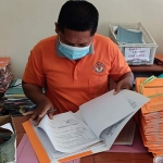 Sulton Nurhadi, salah satu Panitia PTSL Desa Kayunan ketika mengecek berkas pengajuan PTSL. foto: MUJI HARJITA/ BANGSAONLINE