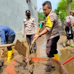 Kapolres Probolinggo AKBP Ferdy Irawan saat ikut membersihkan sisa lumpur pasca banjir.