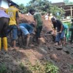 Warga dibantu TNI, Polri, BPBD dan Tagana membersihkan sisa runtuhan tanah yang menutup jalan. (Soewandito/BANGSAONLINE)
