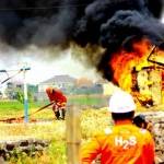 MEMBARA: Kobaran api tampak membara saat proses simulasi di proyek migas JOB PPEJ. Rumah yang terbakar itu hanya buatan dari petugas. foto: eky nurhadi/BANGSAONLINE