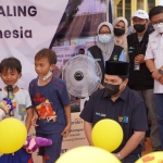 Menteri BUMN, Erick Thohir, bersama Direktur Utama Petrokimia Gresik, Dwi Satriyo Annurogo,  bercengkrama dengan anak-anak korban erupsi gunung Semeru di tenda pengungsian.