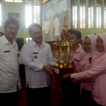 Ditemani Kadisdik Jatim, Pjs Walikota Kediri Jumadi menyerahkan throphy kepada salah satu siswa berprestasi. Foto: Arif K/BANGSAOLINE