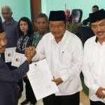 RESMI: Ketua KPU Sidoarjo Mokh Zaenal Abidin menyampaikan berkas penetapan paslon terpilih Pilkada Sidoarjo 2015 kepada H Saiful Ilah yang didampingi H Nur Ahmad Syaifuddin di Kantor KPU Sidoarjo, Selasa (22/12/2015). foto: musta