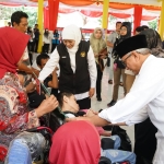 Qowim saat mendampingi Gubernur Jatim menyalurkan Sapa Bansos. 