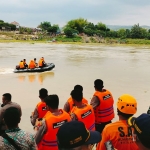 Petugas gabungan saat sedang mencari belasan korban menggunakan perahu karet di aliran Sungai Bengawan Solo yang terpantau banjir dan sedang mengalir deras.