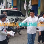 Ketua DPP TKN, Eko Prasetyo, saat membagikan ratusan kaos bergambar Prabowo-Gibran. Foto: SUGIANTO/BANGSAONLINE