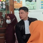 Ahmad Faiz (kiri) saat berkonsultasi dengan penasehat hukumnya usai sidang. Foto: Ist