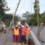 Petugas dari PLN Kediri saat memasang tiang listrik. Foto: Ist.