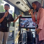 Dua mahasiswa Uniska yang menjadi petugas informasi di dalam bus Satria saat menjelaskan tempat-tempat bersejarah di Kota Kediri. Foto: Ist.