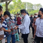 Bupati Bangkalan, R Abdul Latif Amin Imron, saat menyerahkan voucer bantuan untuk pedangan kaki lima dan UMKM.