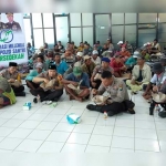 Kapolres AKBP Wahyu S. Bintoro (tengah berkopiah) makan nasi bungkus bersama para tenaga bongkar muat di Pelabuhan Gresik.