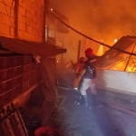 Petugas damkar saat berupaya memadamkan api yang membakar gedung asrama Pesantren Miftahul Ulum.