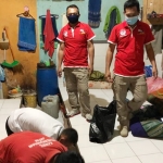 Para petugas sedang melakukan penggeledahan barang-barang penghuni lapas.