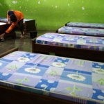 Petugas saat mempersiapkan tempat tidur bagi pasien Covid-19. (foto: kominfo)