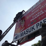 Petugas dari Satpol PP Gresik saat menertibkan reklame yang habis masa izinnya. Foto: Ist