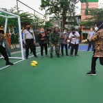 Wali Kota Risma mencoba menendang bola di lapangan olahraga Tambak Asri.