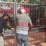 Pepeng Putra Wirawan (Pakaian Batik) saat menyaksikan pembukaan gembok di pintu kelenteng Kwan Sing Bio Tuban.
