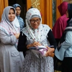 Nyai Hj Alif Fadlilah (paling kiri) bersama putrinya, Neng Zahroh (paling kanan) saat memberikan bingkisan Idul Fitri kepada para janda di kediaman Gus Barra Jalan Siwalankerto Utara, Surabaya Senin sore (3/6/2019). foto: BANGSAONLINE.com