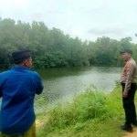 Anggota Polsek Karang Penang saat menyisir waduk Tlambah TKP hilangnya korban