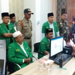 Rombongan GP Ansor dan Banser Bangkalan melaporkan akun Mustafa Maksum dibruangan SPKT Bangkalan. Inset: Postingan Mustafa Maksum di akun facebooknya.