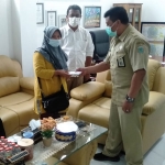 Woko, Kabid Bina Marga mewakili DPUPR Kota Batu menyerahkan bantuan Rp 5 juta kepada Setiyo, istri korban, Solikin, Senin (15/11). Foto: Ist.