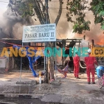 Petugas saat memadamkan kobaran api yang menghanguskan Pasar Baru II milik Pemkab Gresik. Foto: SYUHUD/BANGSAONLINE