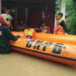 Tim SAR saat mengevakuasi warga di Desa Pengkol menggunakan perahu karet.