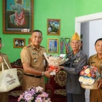 Kabag Kesra Pemkot Kediri, Jainudin (kanan), bersama Camat Mojoroto, Bambang Tri, ketika menyerahkan bingkisan kepada veteran perintis kemerdekaan. Foto: Ist