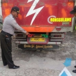 Petugas mengamankan truk yang terlibat kecelakaan.