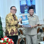 Bupati Fadeli menerima buku tentang ekonomi syariah dari Direktur Pusat Kajian Strategis Baznas Irfan Syauqi Beik.