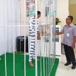 Ada sebuah jeruji besi yang di dalamnya terdapat seorang tahanan di kantor BPJS Ketenagakerjaan Jember.