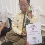 Achmad Misbachul Munir memegang piagam penghargaan yang telah diraihnya. Foto: bangsaonline