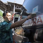 Kepala Dishub Kota Surabaya Irvan Wahyudrajat saat menempelkan stiker laik jalan. foto: ist