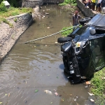 Mobil pikap tercebur ke sungai usai terlibat kecelakaan dengan motor. foto: MUJI HARJITA/ BANGSAONLINE
