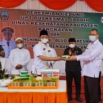 Bupati Bangkalan, R Abdul Latif Amin Imron, saat memberikan potongan tumpeng kepada Kepala Dinkes Bangkalan, Sudiyo.