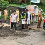 Petugas dari BPBD Kota Batu saat meninjau dampak longsor dan banjir.
