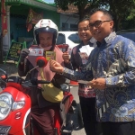 Kajari Kabupaten Kediri, Chandra Eka Yustisia (kanan), didampingi Kasi Intelijen Kejari Kabupaten Kediri, Roni, saat membagikan stiker antikorupsi kepada salah satu pengguna jalan. Foto: Ist