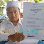 Kepala MDT Wustha Miftahul Ulum Abdul Wahid saat menunjukkan BPPDGS. Foto: MUTAMMIM/ BANGSAONLINE