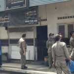 Kepala Dispol PP Achmad Nuruddin bersama pejabat Muspika Gresik saat menertibkan warkop di Jalan Malik Ibrahim. foto: SYUHUD/ BANGSAONLINE