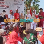 Anggota DPR RI dari Gerindra, Hilmi, didampingi Sekretaris DPC Gerindra Gresik, Nur Saidah, saat menyerahkan hadiah sepeda ontel kepada peserta jalan sehat yang beruntung. Foto: SYUHUD/BANGSAONLINE