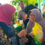 Gubernur Jatim Khofifah Indar Parawansa turut melayani warga yang berbelanja sembako di Pasar Murah.